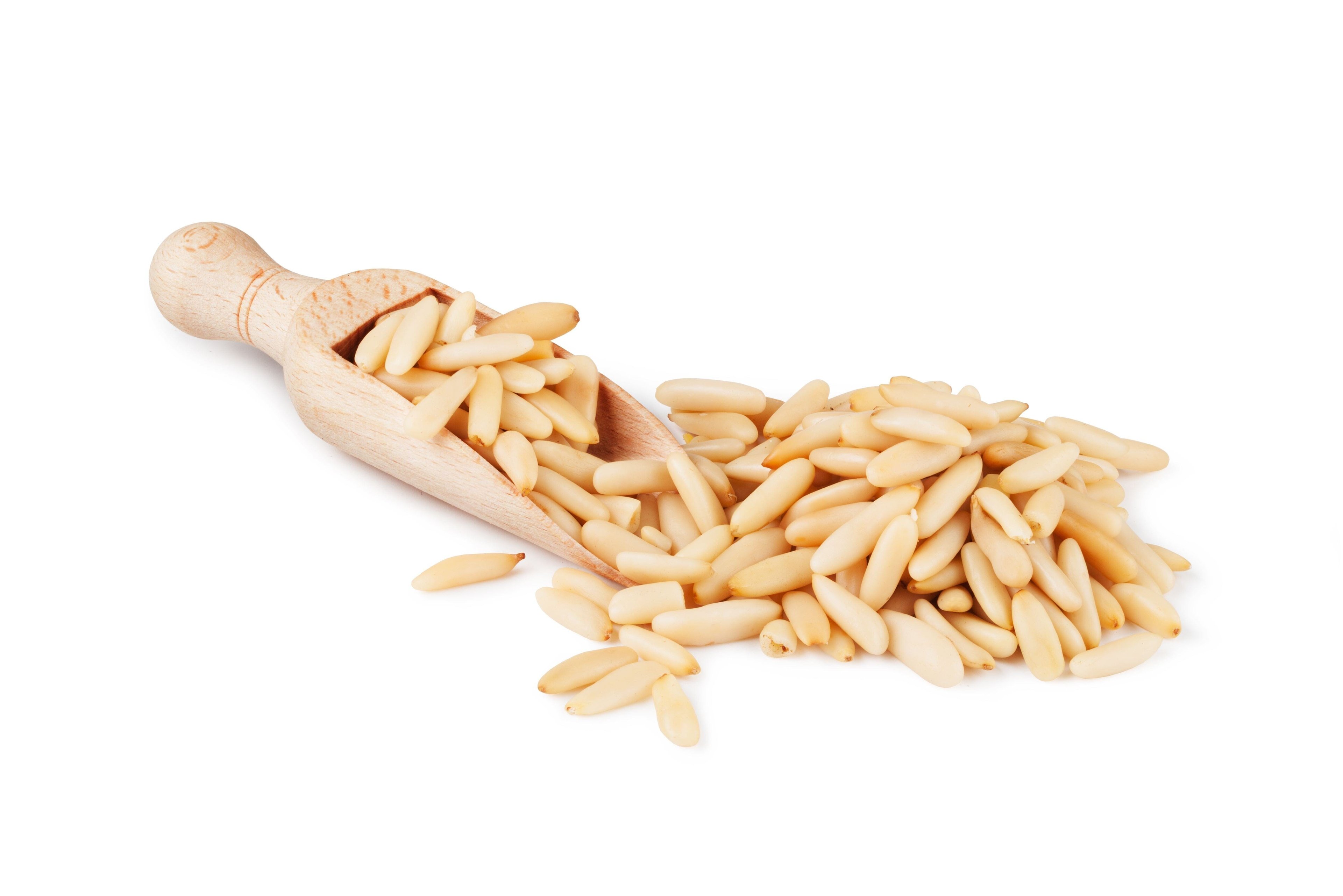 Image of a wooden scoop full of Pine nuts