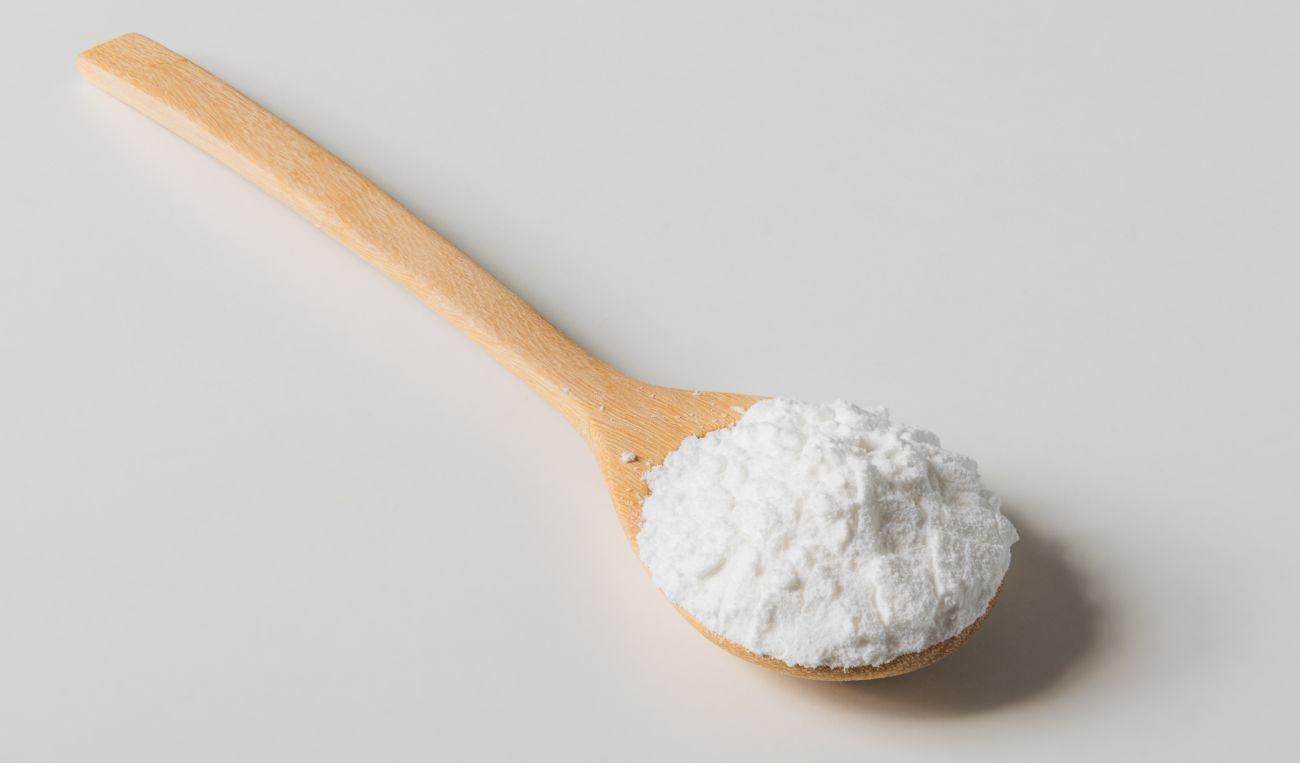 This is a picture of allulose sweetener on a wooden spoon on a light background