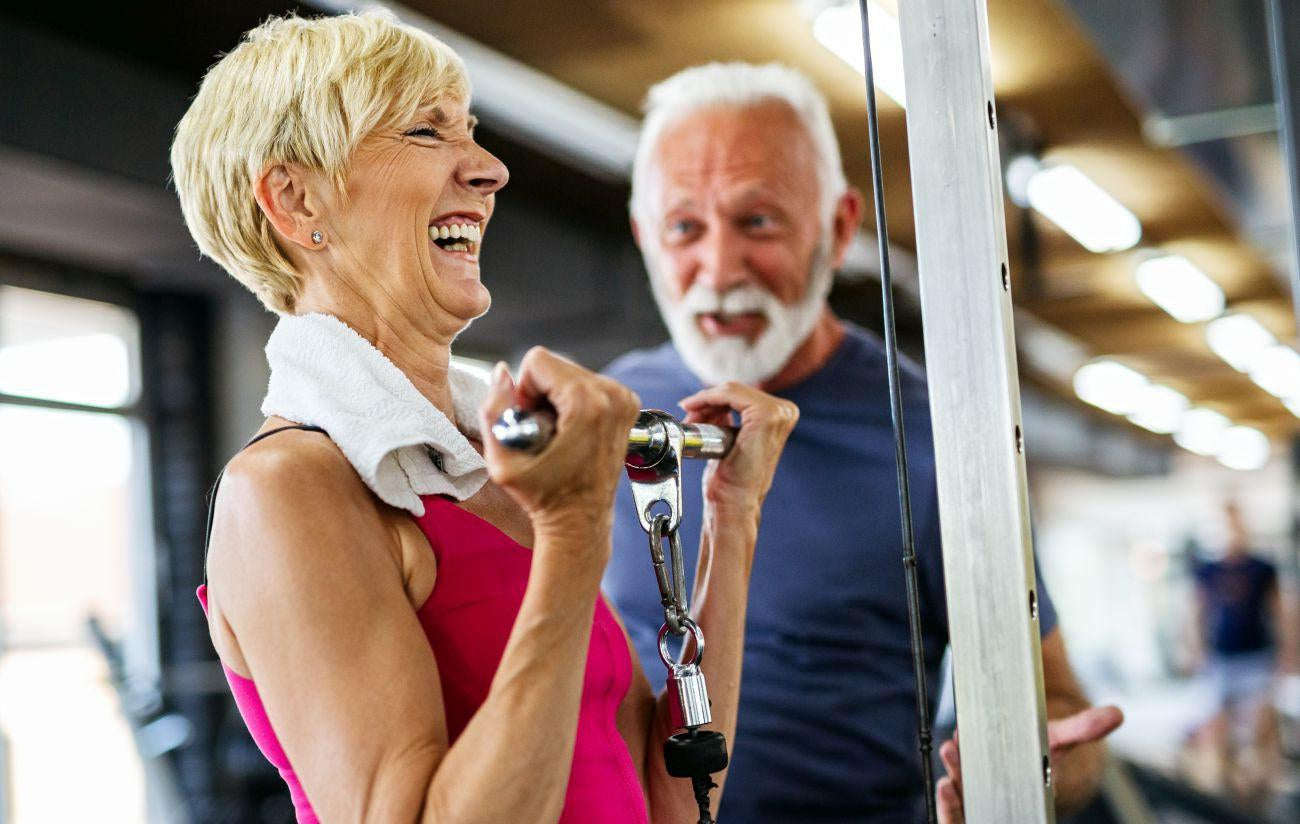 This is a picture of a woman doing a barbell curl and a helpful man coaching her along