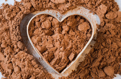 This is a picture of cacao powder in the shape of a heart on a light colored background