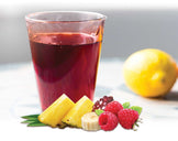 Glass of Berry Punch Collagen Peptides drink with cut fruit next to it