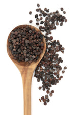 Image of whole black pepper kernels in a wooden spoon