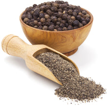 Image of black peppercorns in a wooden bowl and ground black pepper in a wooden spoon