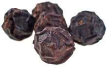 Close photo of 5 dried black peppercorns on white background