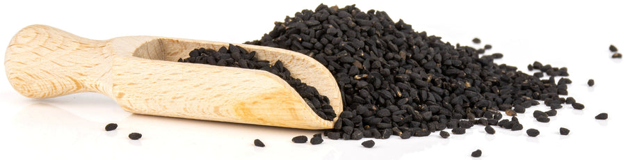 Image of Black Seeds with wooden serving scoop in front on white background.