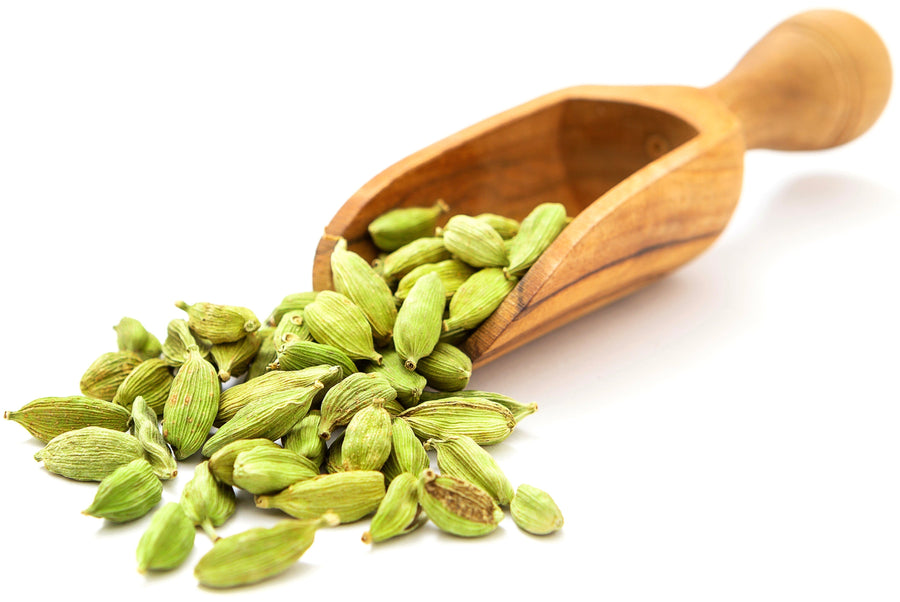 Image of Cardamom Seeds with wooden serving spoon on white background