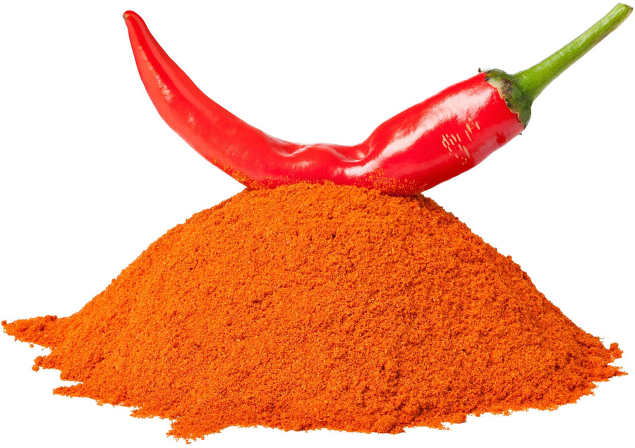 Cayenne Pepper Powder with Cayenne Peppers laying on pile