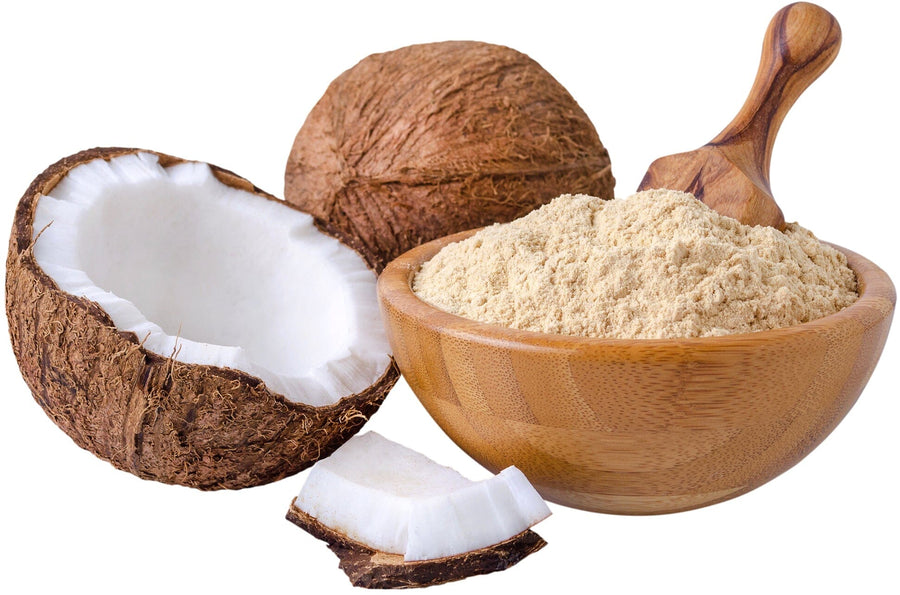 Photo of wood bowl full of Coconut Flour with a whole and half coconut next to the bowl