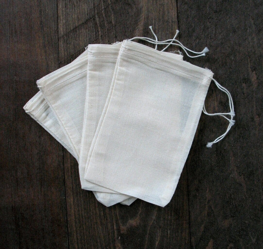 Photo of 4 large Cotton Muslin Bags sitting on dark wood background