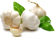 Image of Garlic clove with three whole garlics in background.
