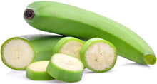 Photo of whole green unripe banana with slices of unripe banana 