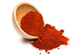 Image of spilled Ground Paprika from wooden bowl on white background