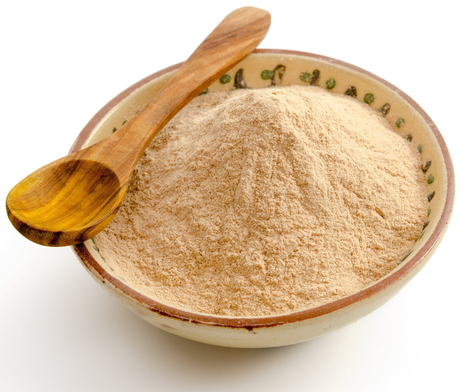 A pile of Lucuma Powder with a wooden spoon and bowl on white background