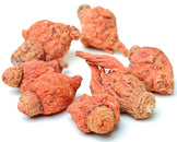 Image of seven dried red Maca Roots on white background.