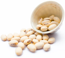 Image of a bunch of white Mucuna Pruriens Seeds and a white cup