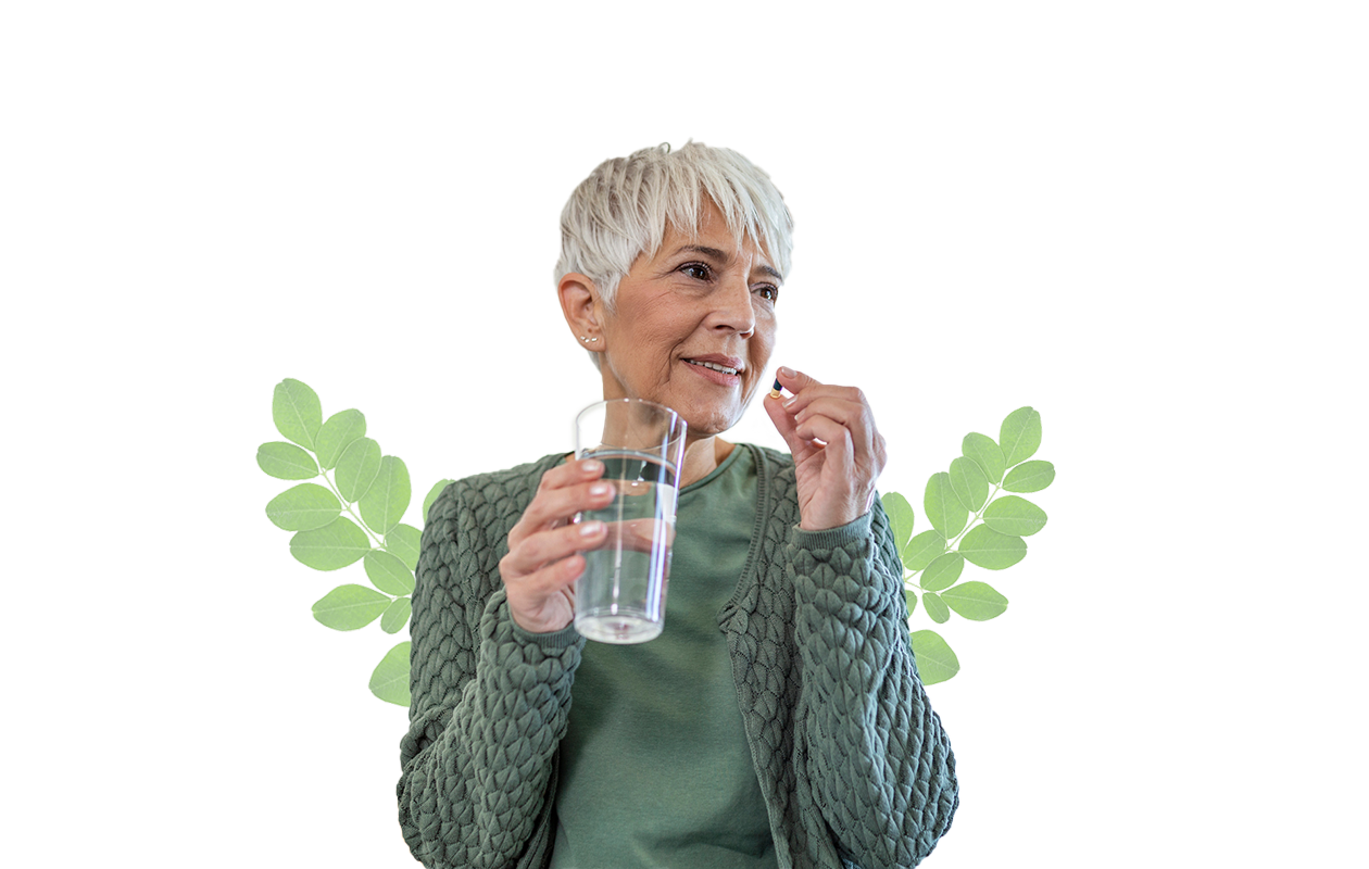 Image of woman about to take a vitamin with glass of water.
