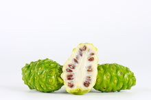 Image of 2 whole green noni fruits and one cut in half