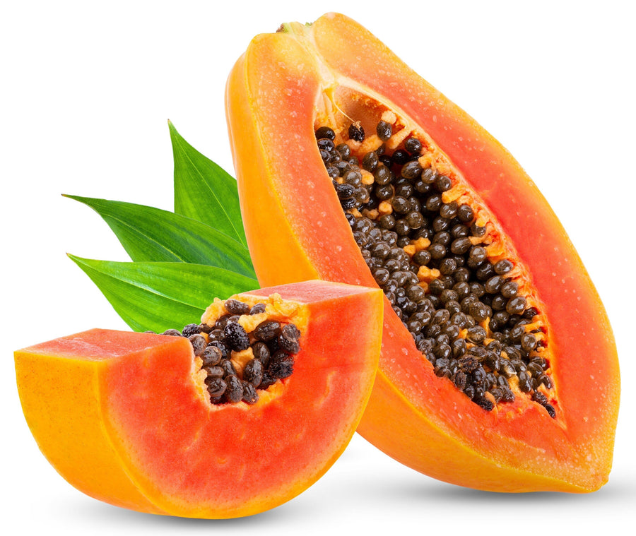 Image of sliced Papaya with halved papaya in background and leaves
