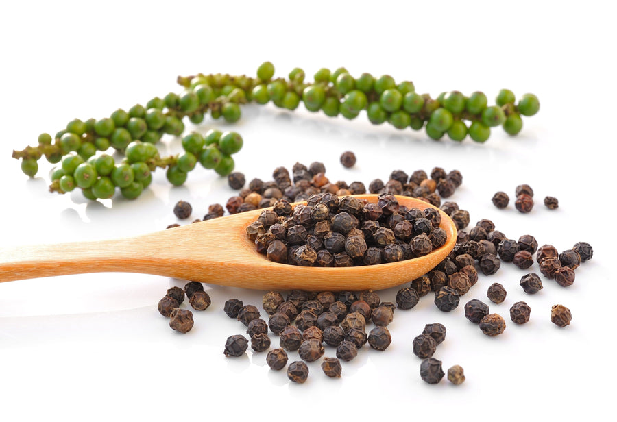 Image of black and green peppercorns and a wooden spoon