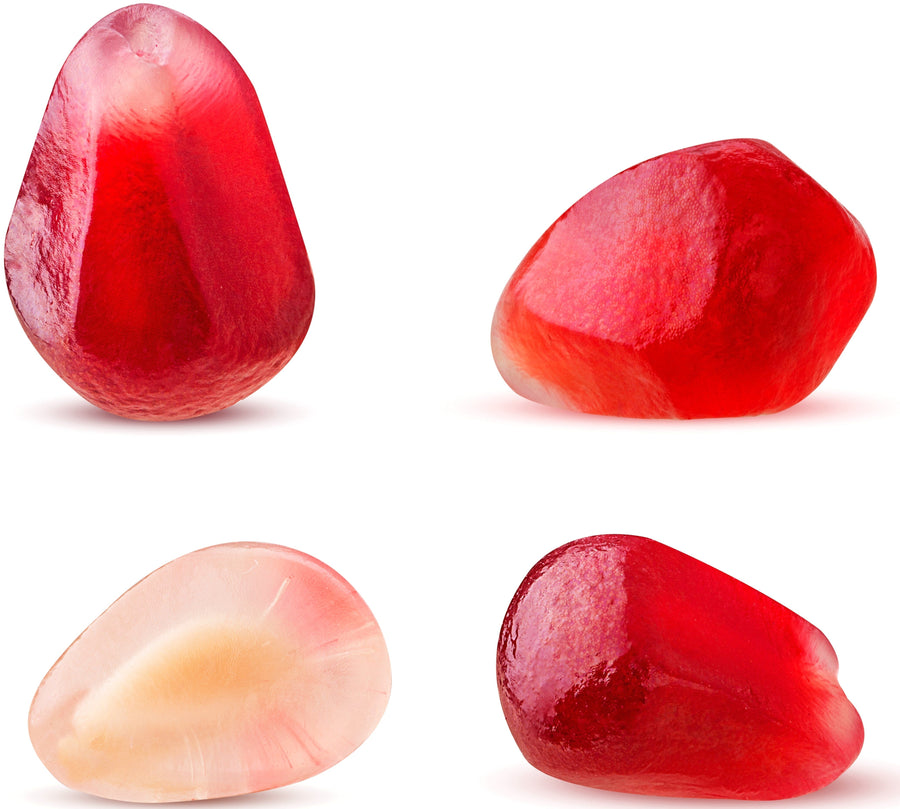 Close up image of different colored pomegranate seeds going from pink to red