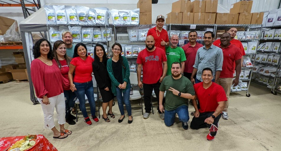 Image of Z Natural Foods employees posing for picture in the warehouse.