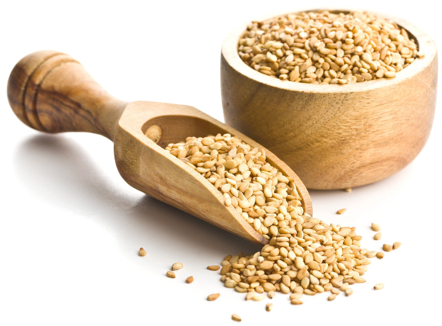 Image of hulled Sesame Seeds in wooden bowl and wooden serving scoop on white background