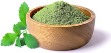 Image of fresh green Stevia Leaf and stevia leaf powder in a wooden bowl