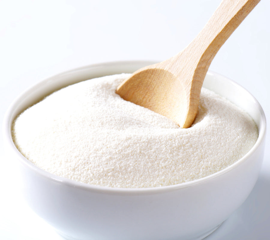Image of Whey Protein Concentrate in white bowl with wooden serving spoon inserted.