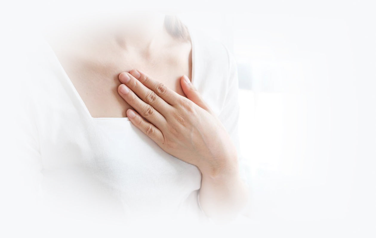 image of woman holding her chest due to acid reflux