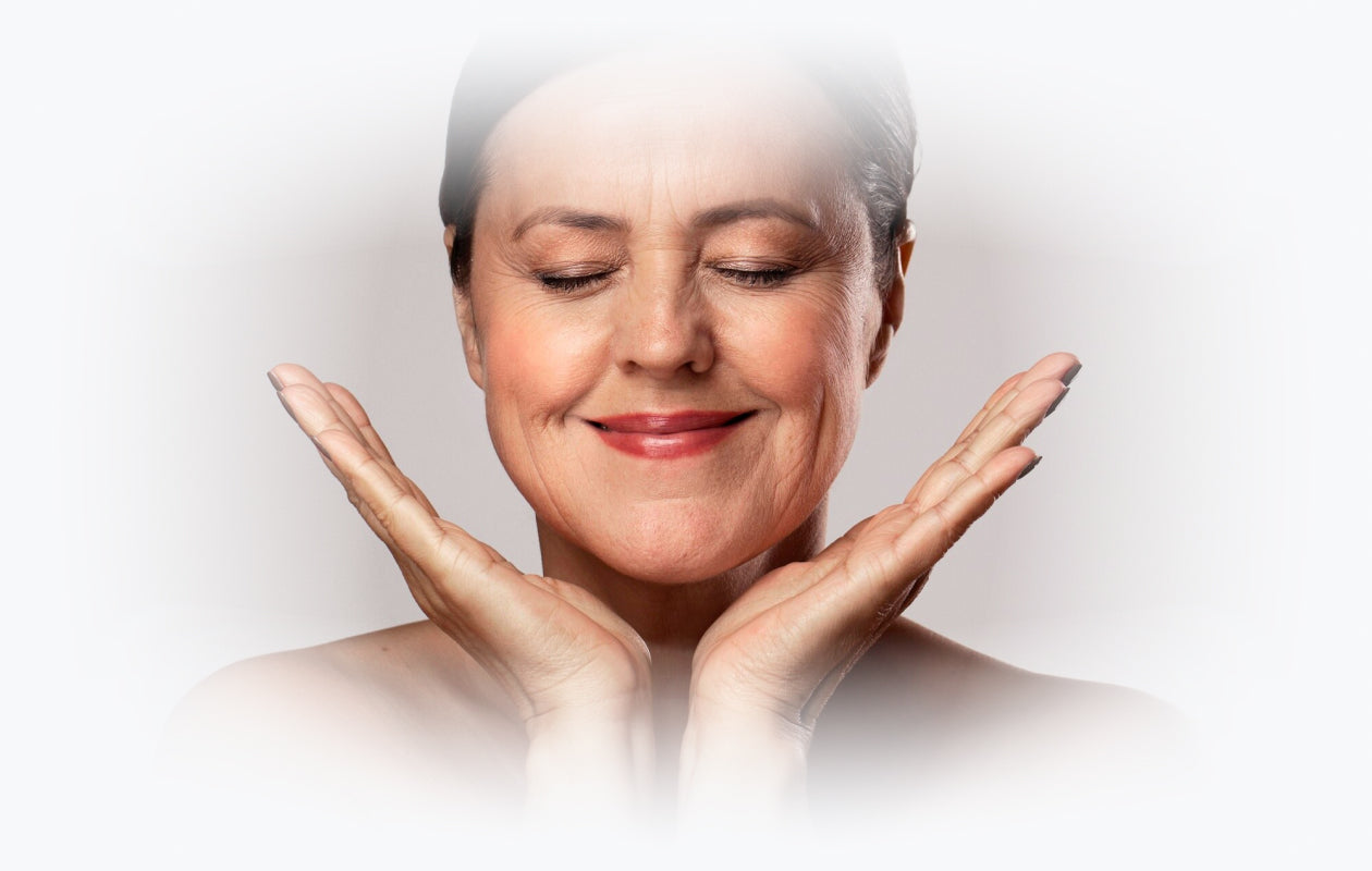 Image of woman smiling with her eyes closed and hands held under her chin and jaw line