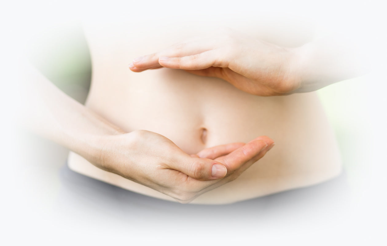 Woman holding hands in front of her stomach depicting healthy digestion