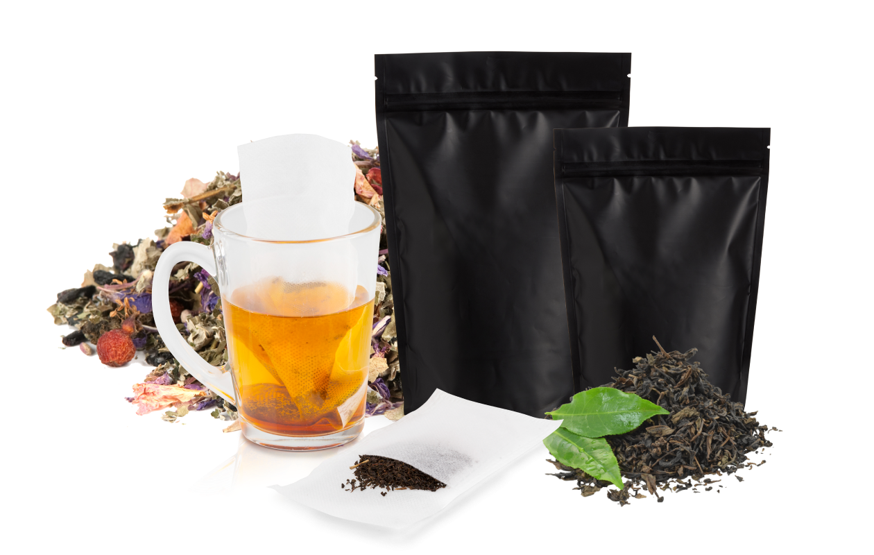 Cup of tea displayed with tea bags and stand up foil bags with various dried tea leaves in background.